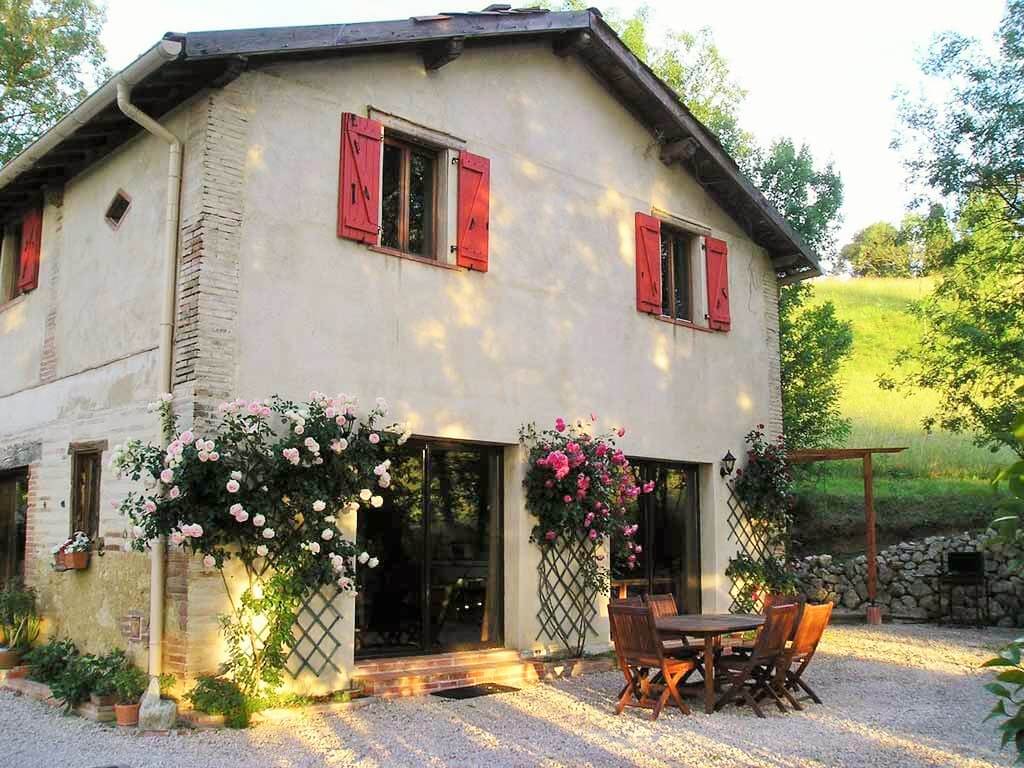 vue de côté de la maison Occitane avec rosiers grimpants