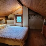 chambre mezzanine avec lit double, plafond en bois