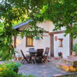 terrasse ombragée avec table et chaises en bois gîte Ostal