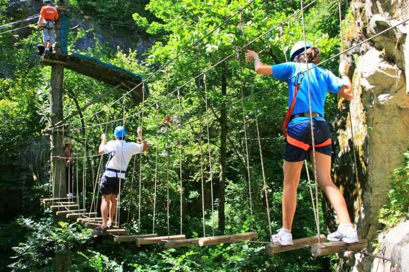 jeu d'accrobanche avec personnes sur une passerelle qui bouge